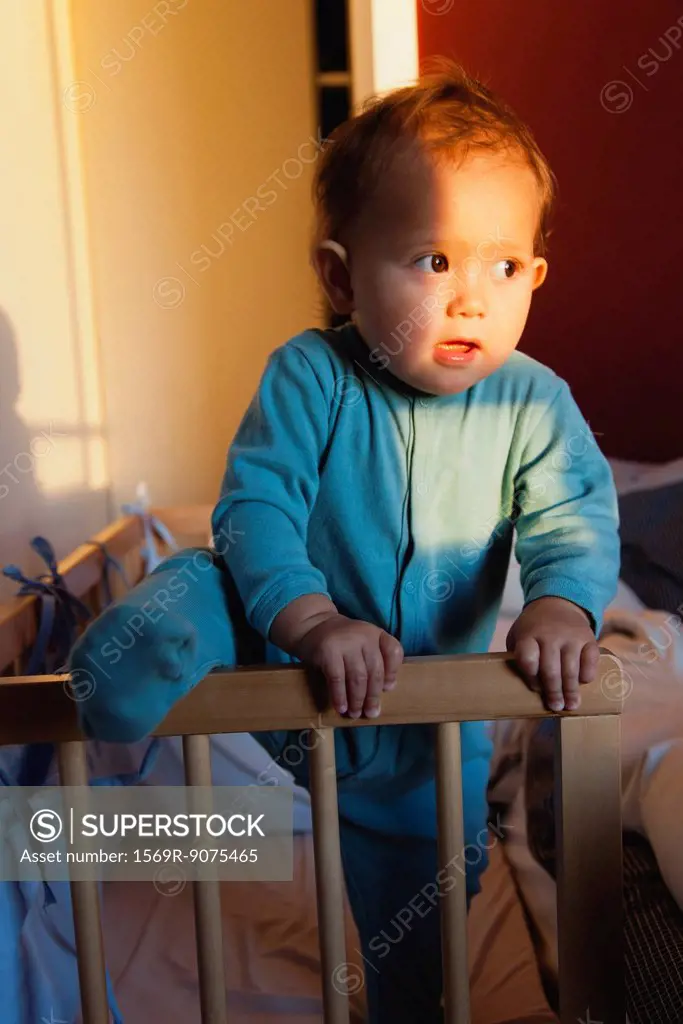 Baby girl climbing out of crib