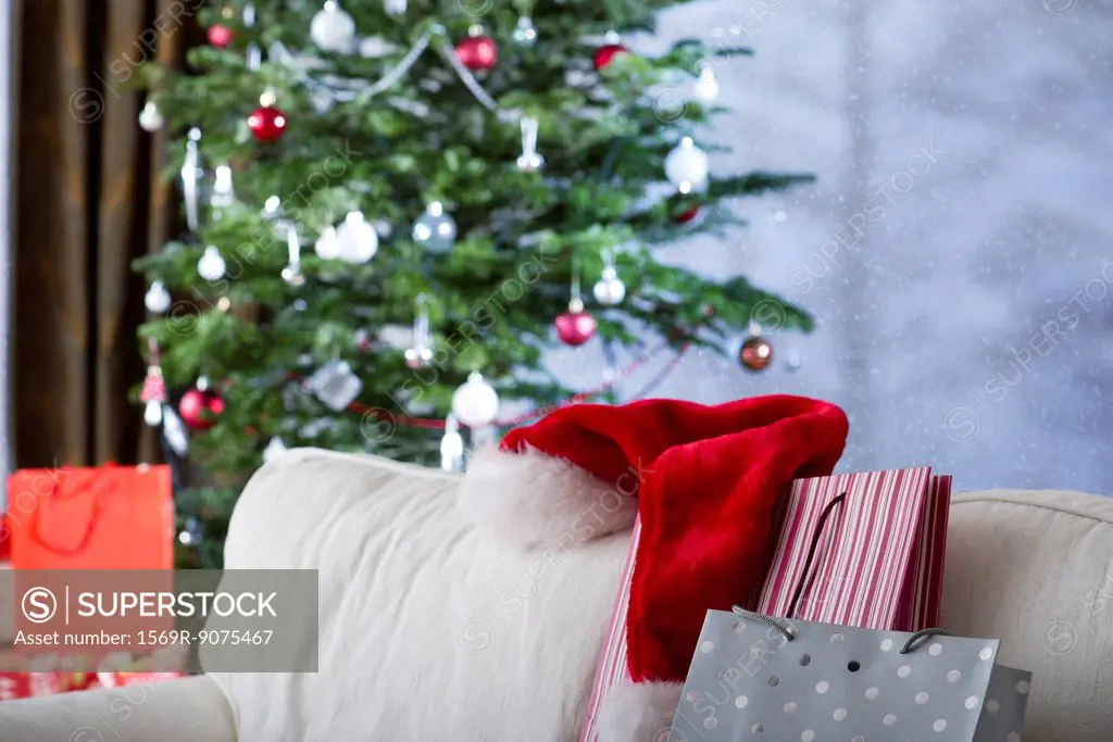 Christmas gifts and Santa hat on sofa