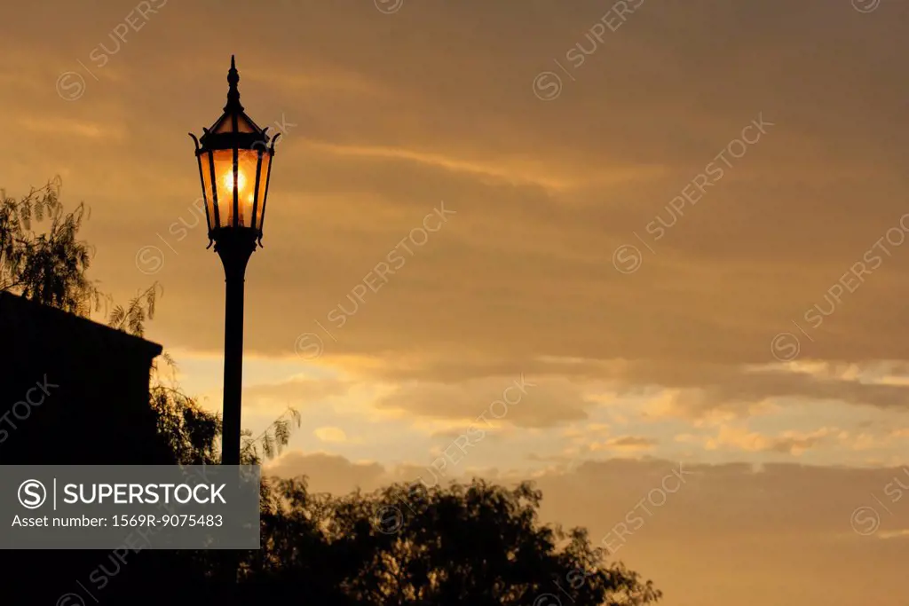 Street lamp illuminated at sunset