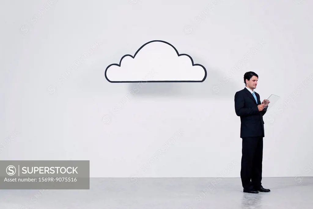 Businessman using digital tablet beneath cloud representing cloud computing