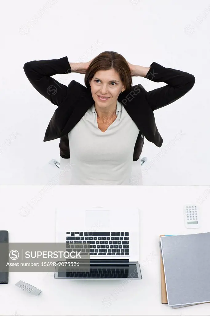 Businesswoman relaxing at desk, high angle view