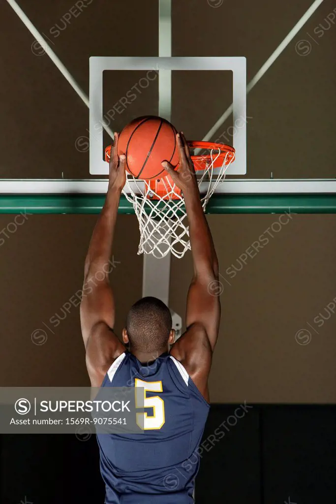 Basketball player making a basket, rear view