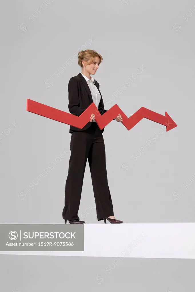 Businesswoman walking on balance beam, carrying large arrow indicating profits