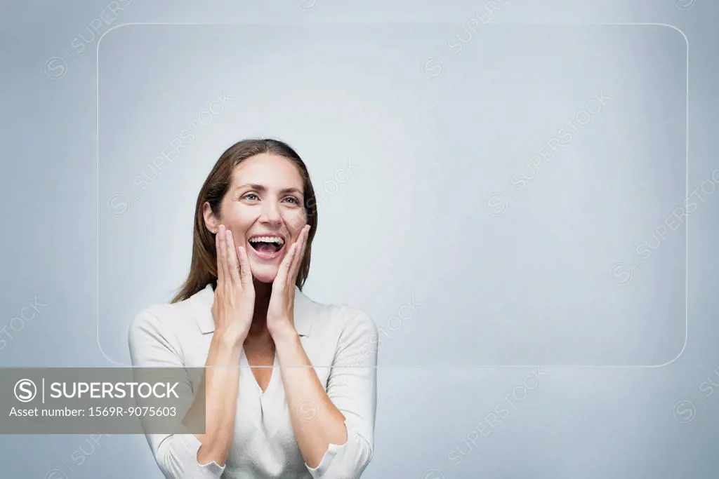 Woman looking at large transparent touch screen with surprised expression on face