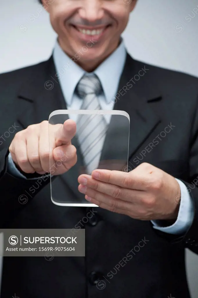 Businessman using transparent digital tablet