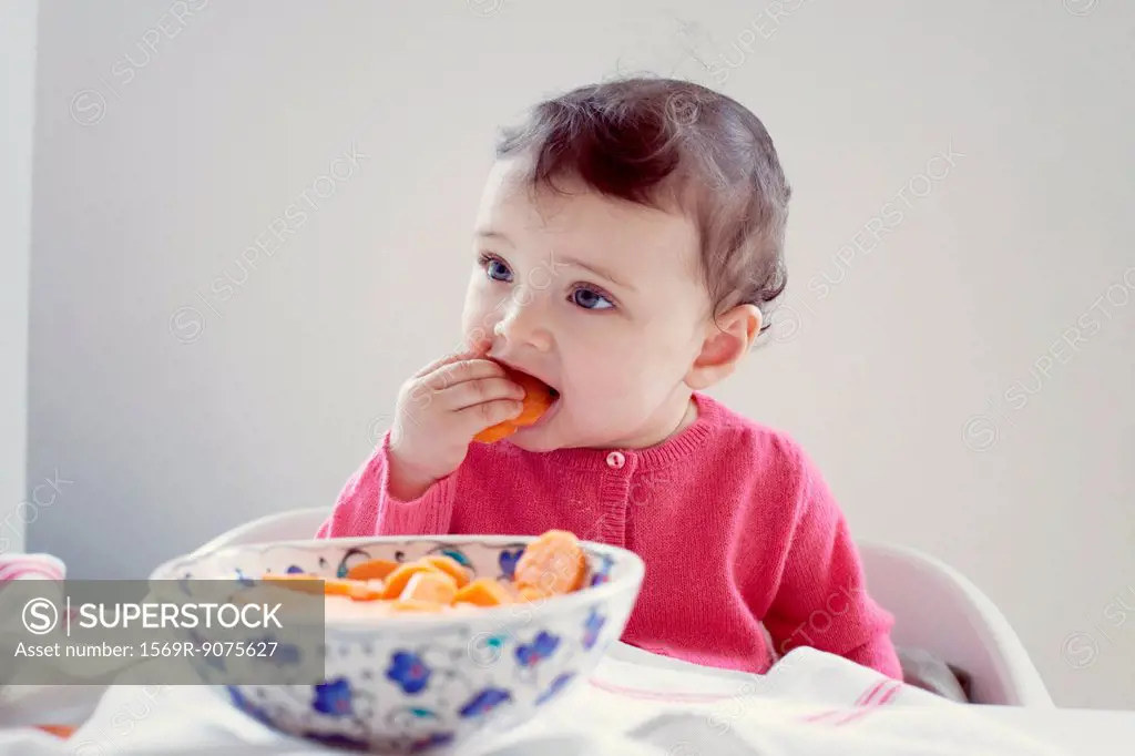 Infant eating carrots, portrait