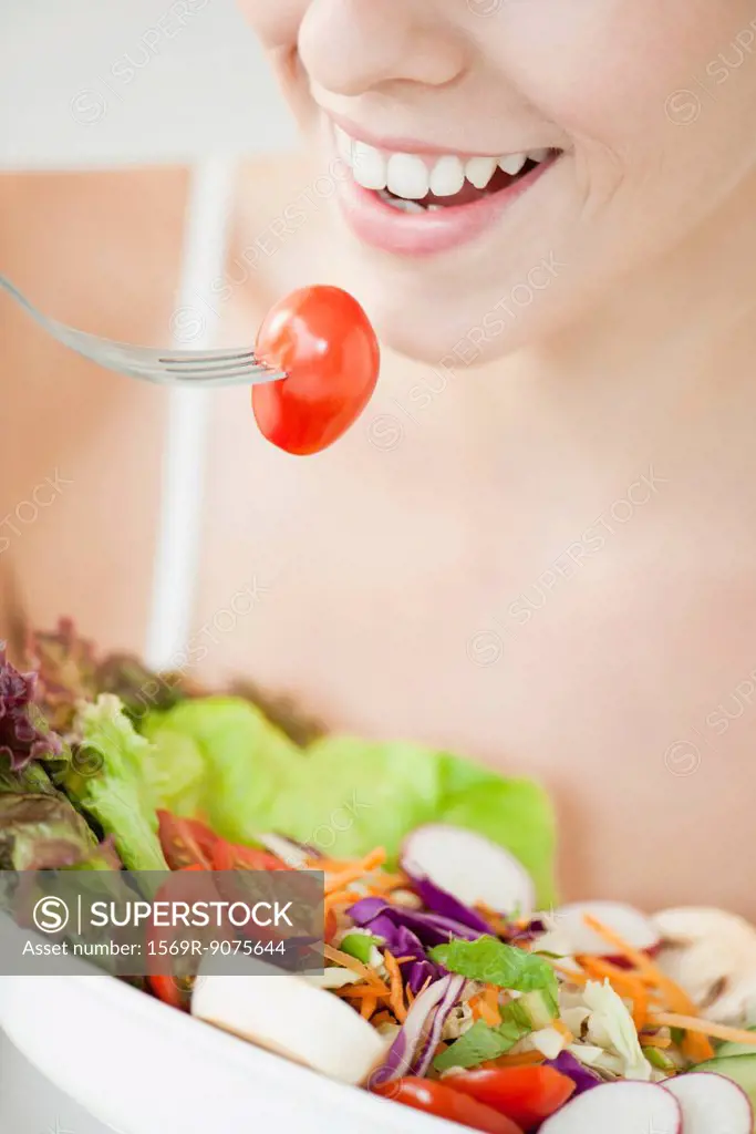 Woman eating salad, cropped