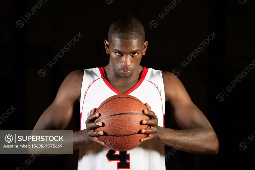 Basketball player holding basketball, portrait