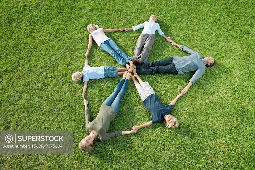 People on grass forming shape of shield