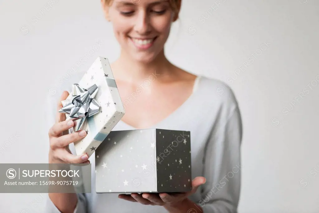 Young woman opening gift box