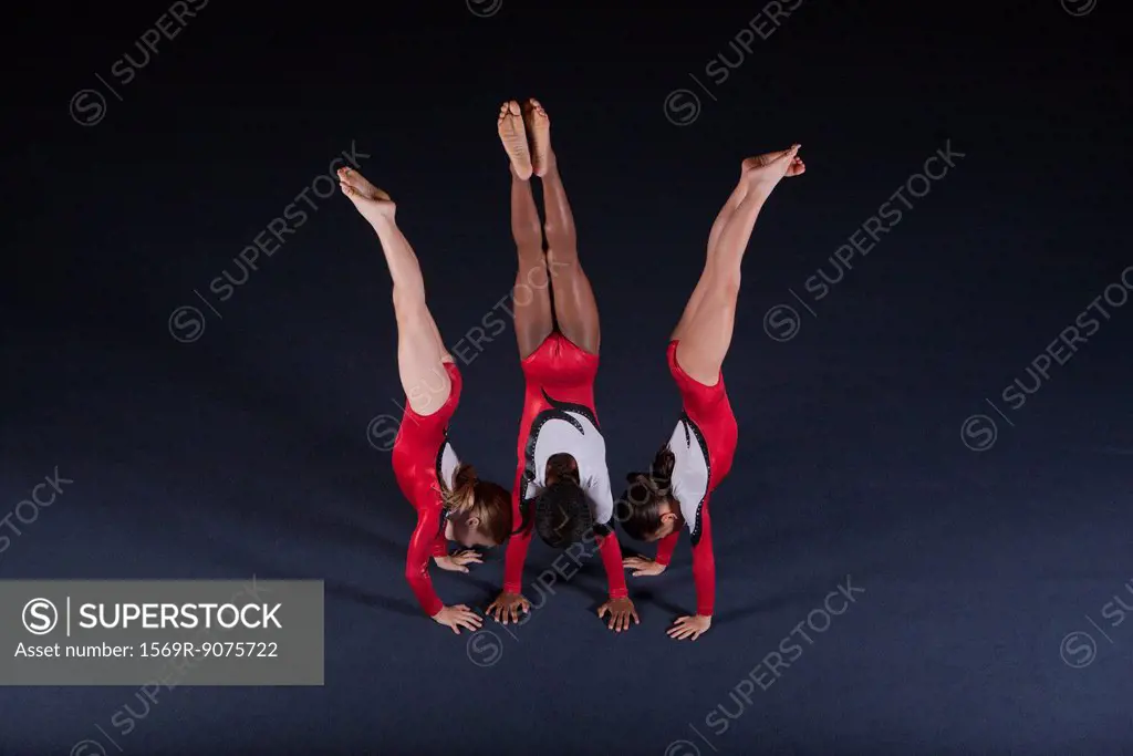 Young female gymnasts performing handstands