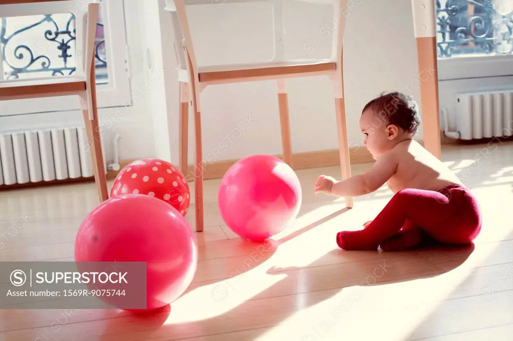 Infant playing with ballons