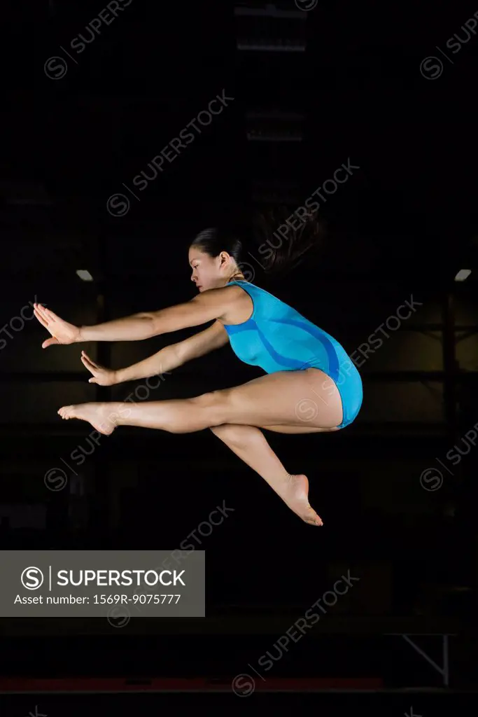 Teenage girl gymnast jumping in air
