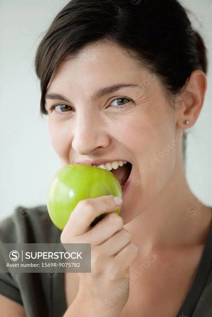 Mid_adult woman biting into apple