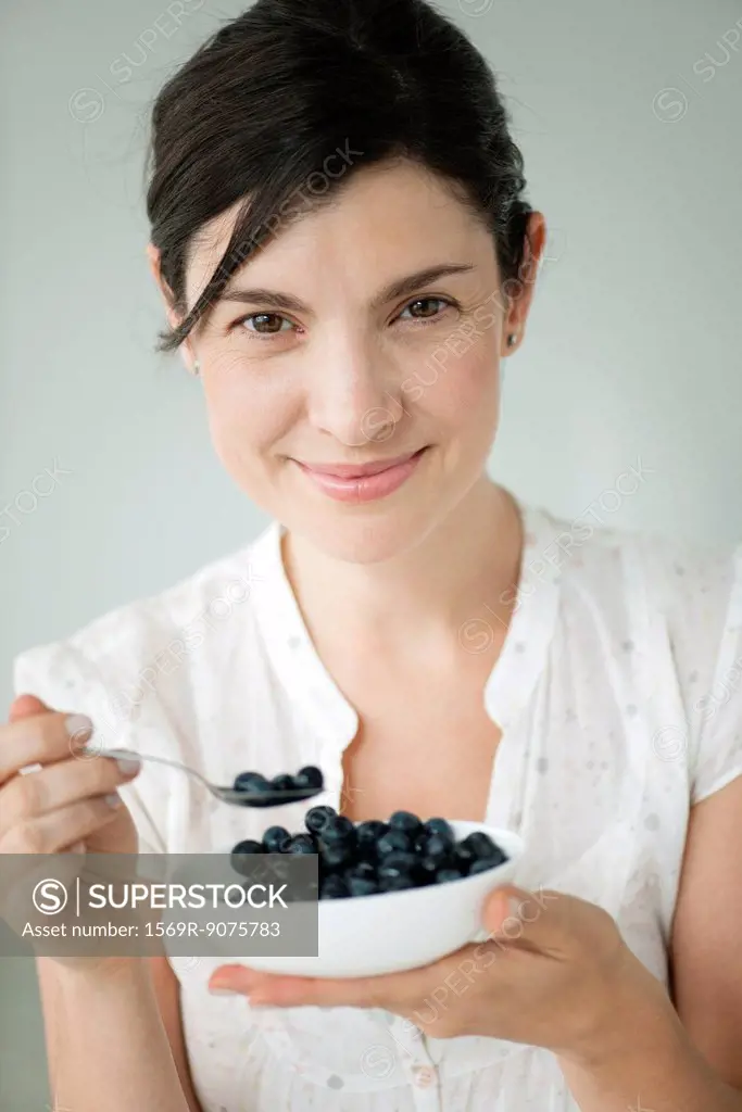 Mid_adult woman with bowl of blueberries