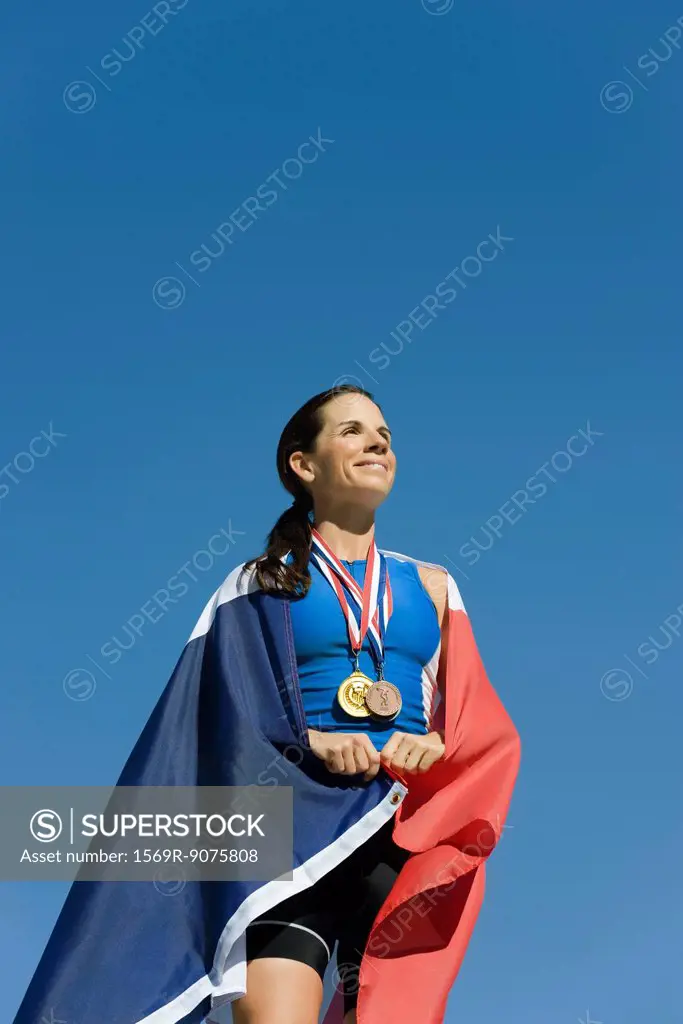 Female athlete on winner´s podium, wrapped in French flag