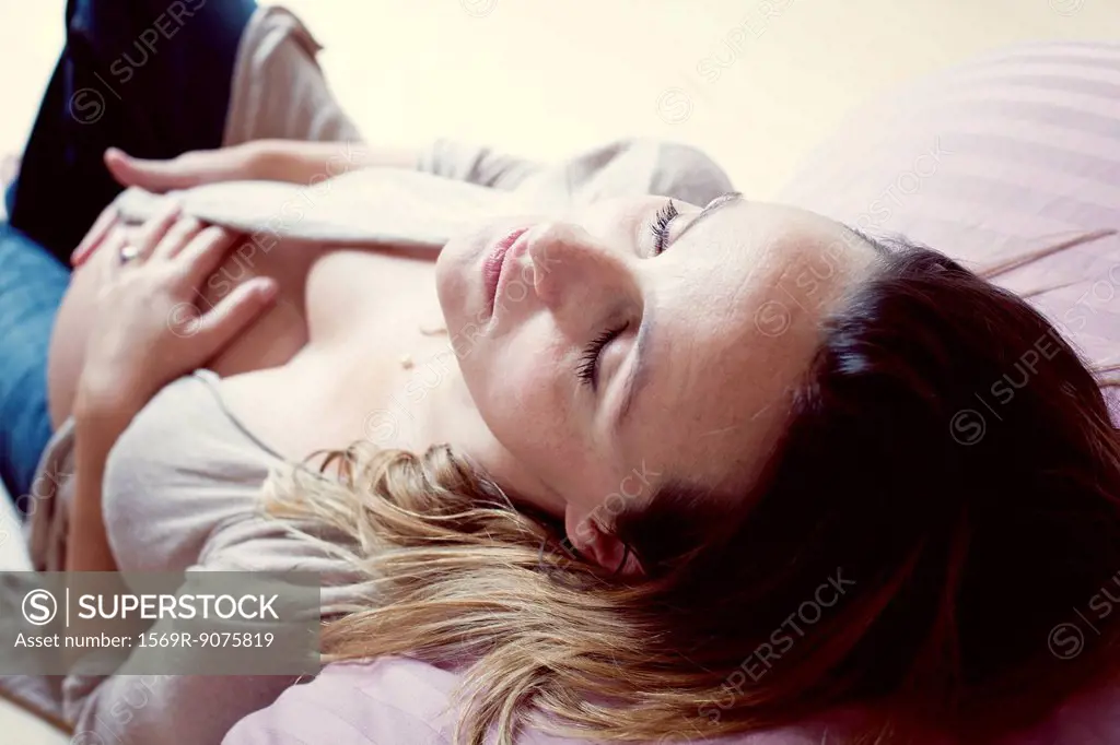 Pregnant woman relaxing with eyes closed, high angle view