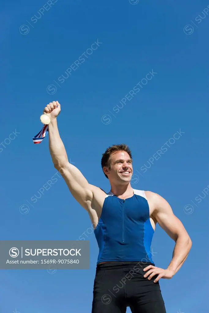 Male athlete holding up gold medal