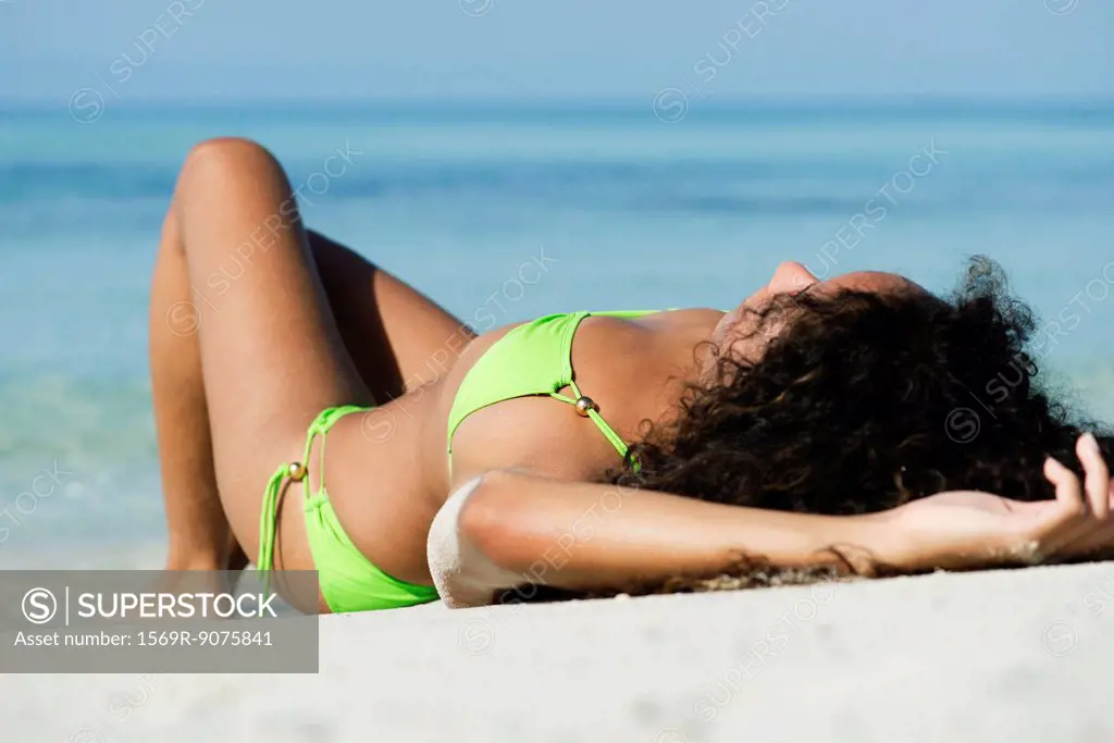 Woman in bikini sunbathing on beach