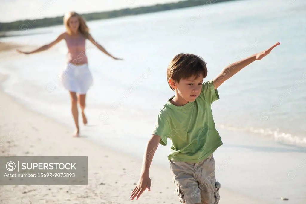 Boy running with arms out at the beach
