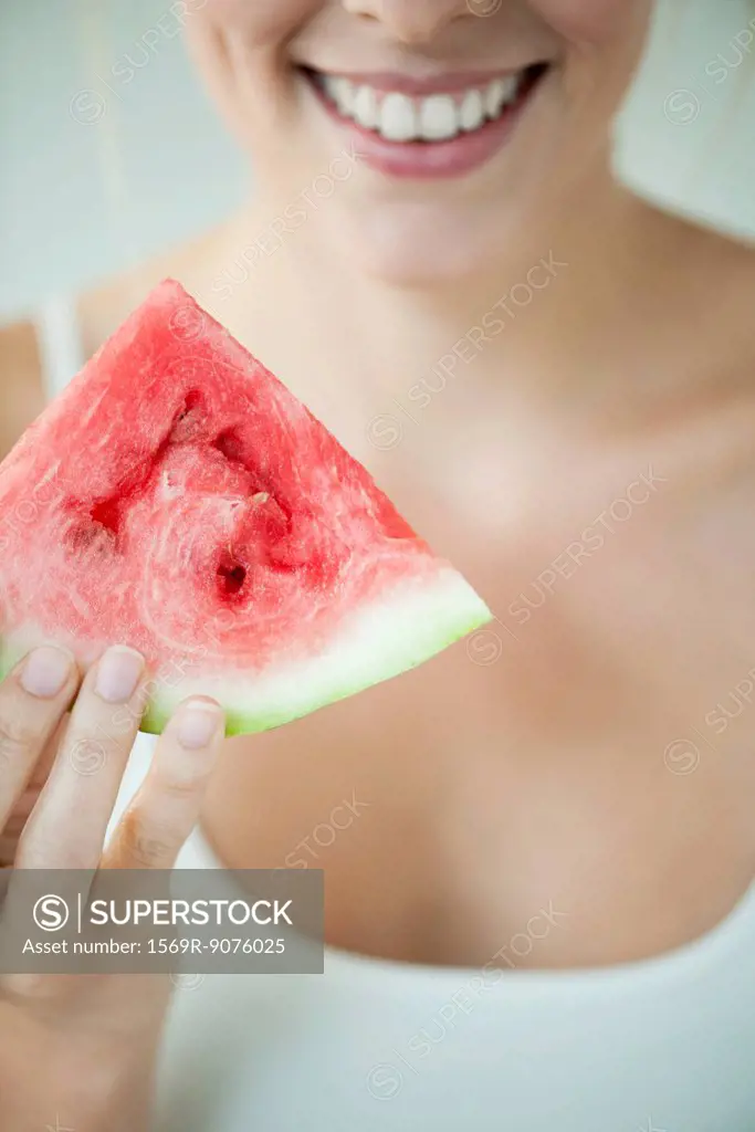 Woman holding slice of watermelon