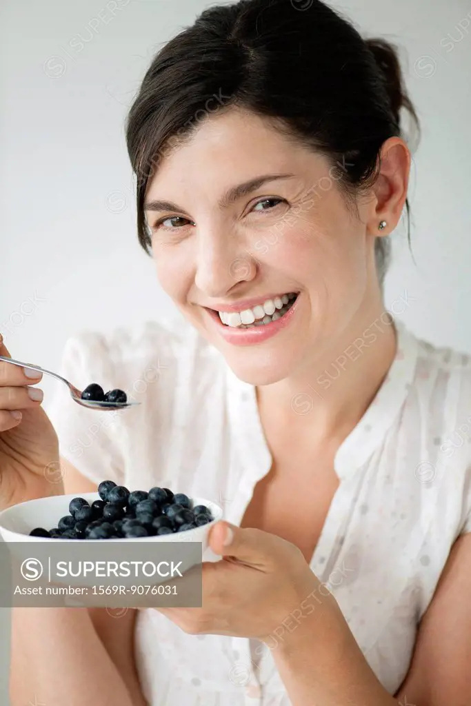 Mid_adult woman with bowl of blueberries