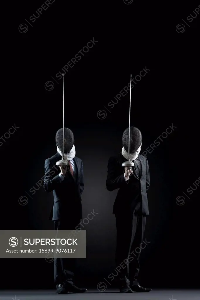 Businessmen with fencing masks holding up fencing foils