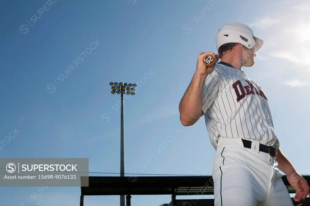 Baseball player holding bat, looking over shoulder