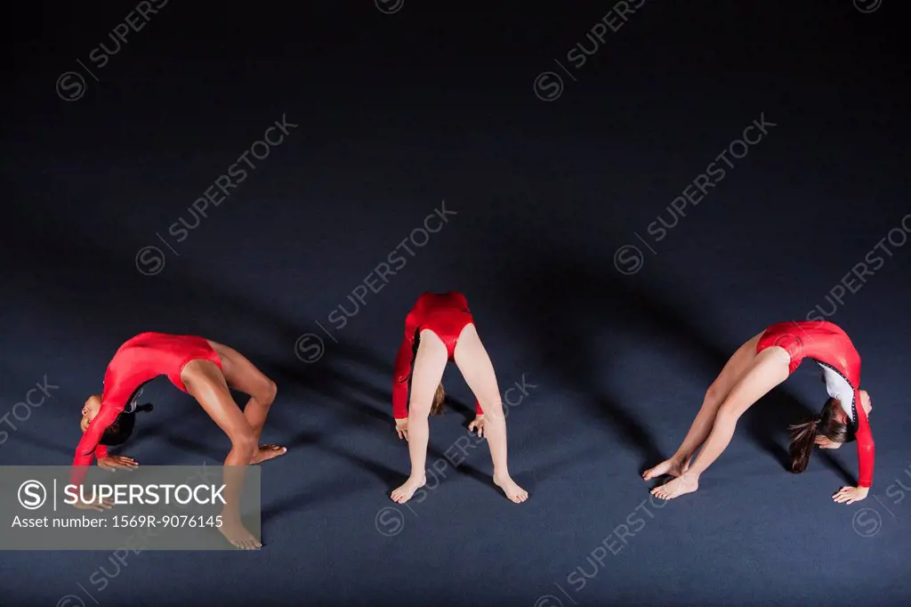 Young girl gymnasts performing backbends