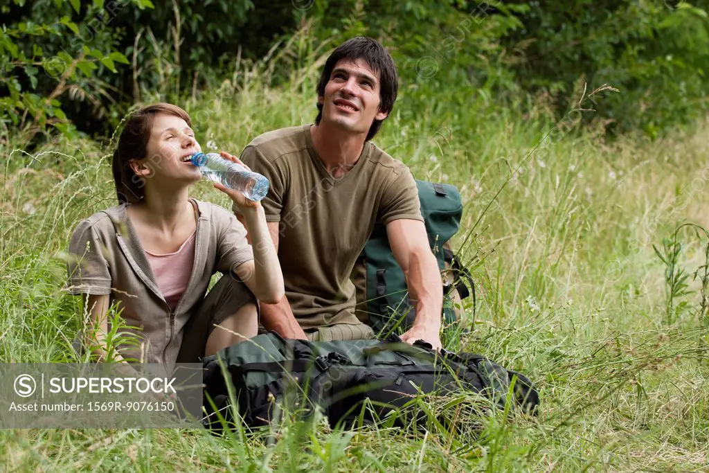 Hiking couple relaxing in meadow