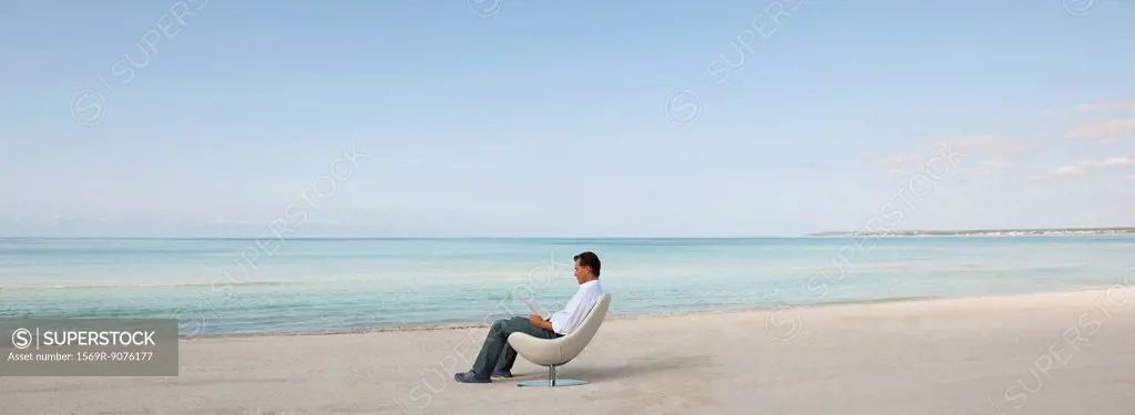 Man reading book at the beach