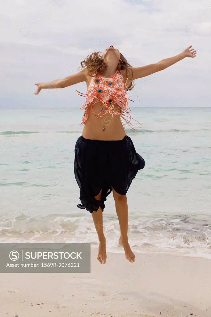 Woman jumping in midair at the beach