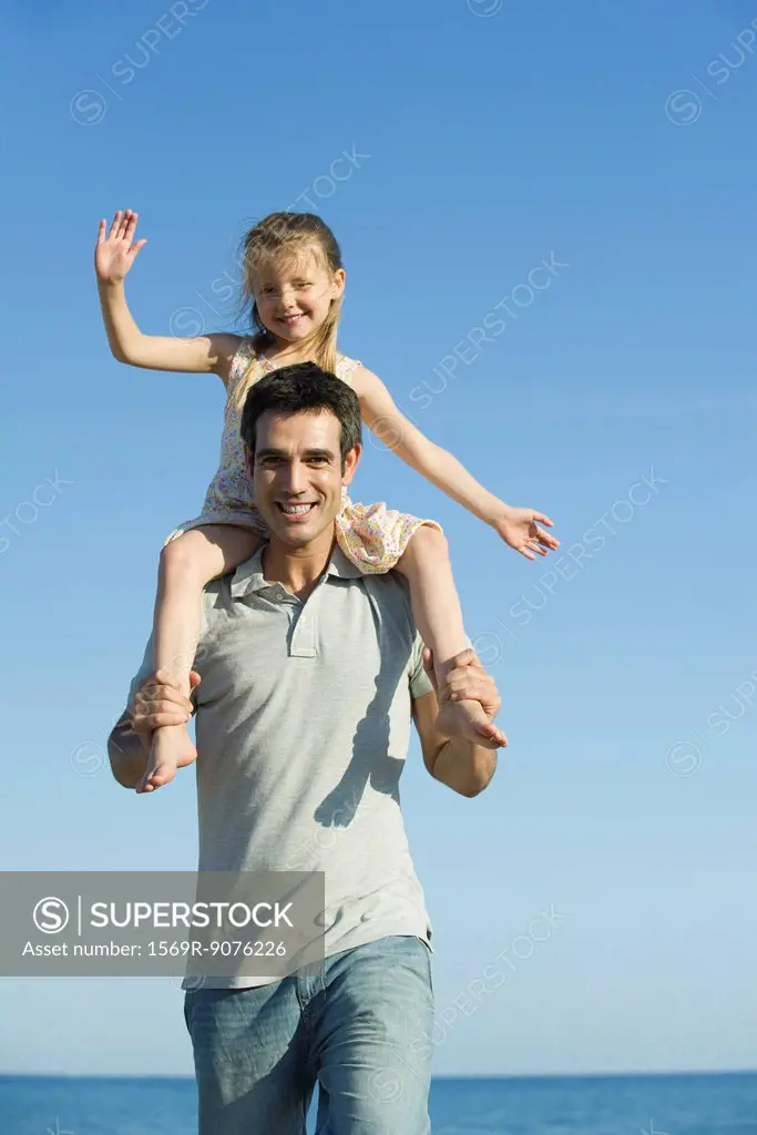 Father carrying daughter on his shoulders