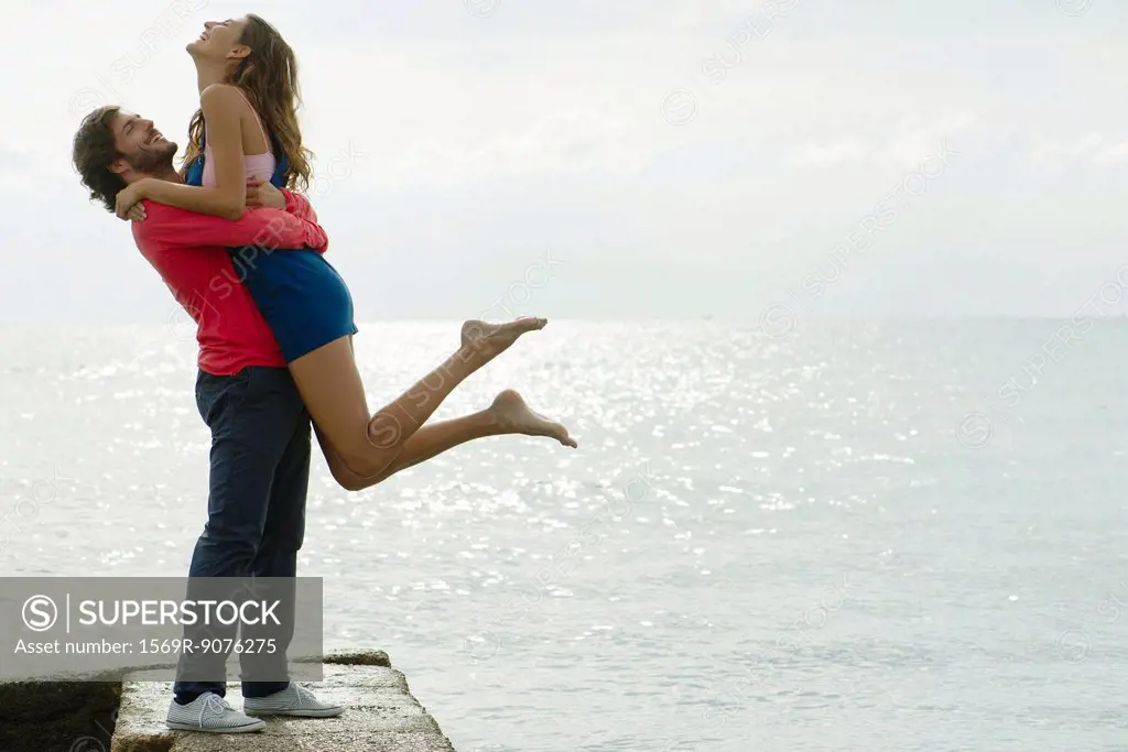Young man lifting girlfriend up, portrait