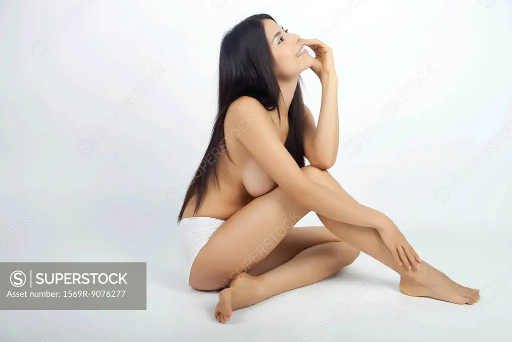 Woman sitting in underwear, daydreaming