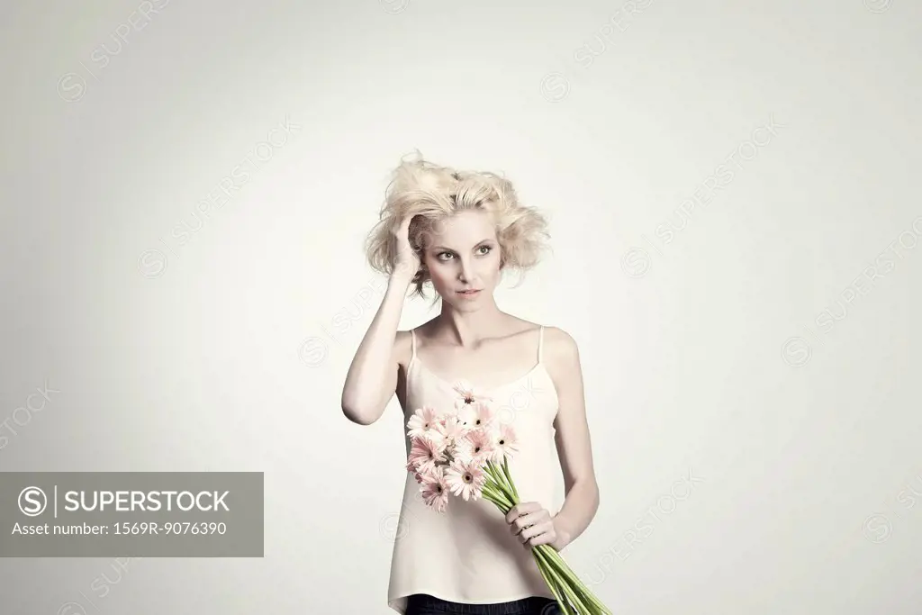 Young woman holding bunch of gerbera daisies, portrait