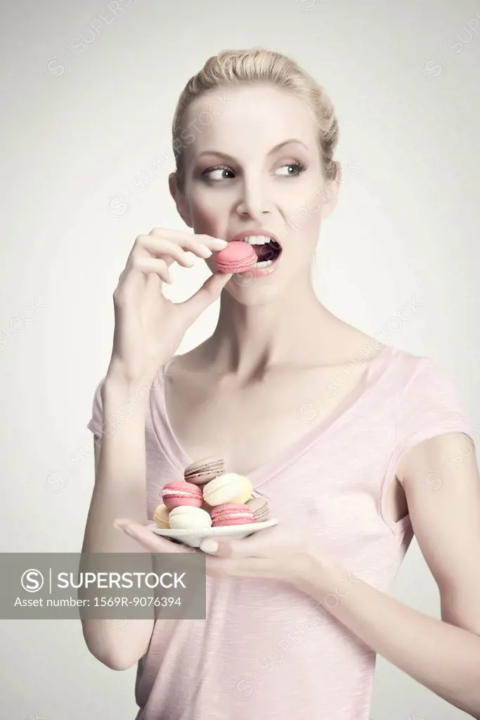 Young woman with plate of macaroons, portrait