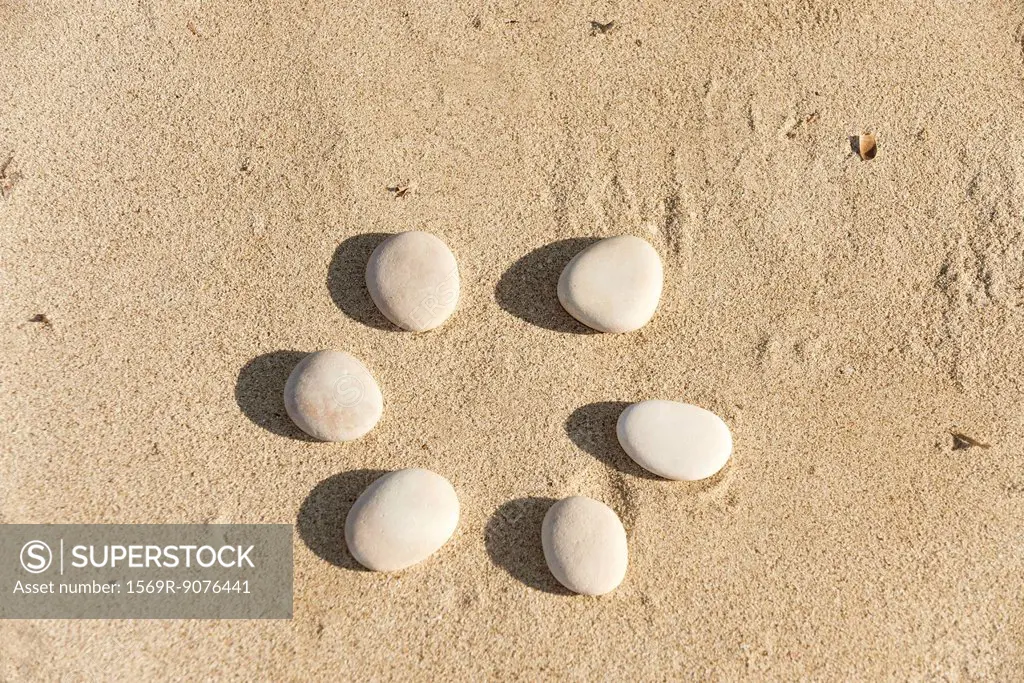 Pebbles arranged in circle on sand