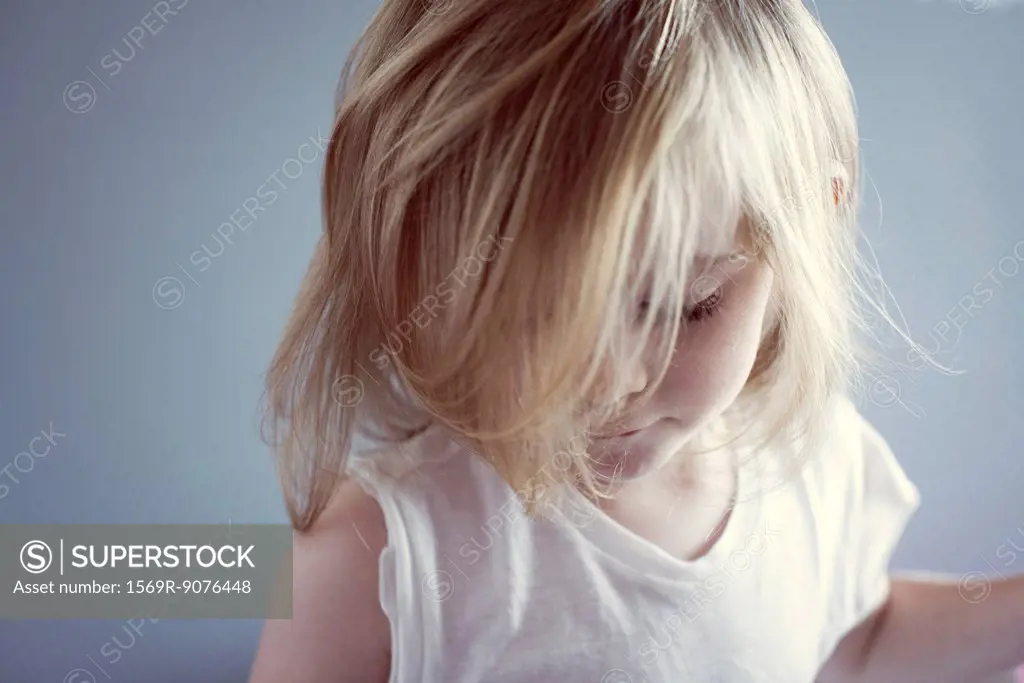 Little girl looking down, hair covering face