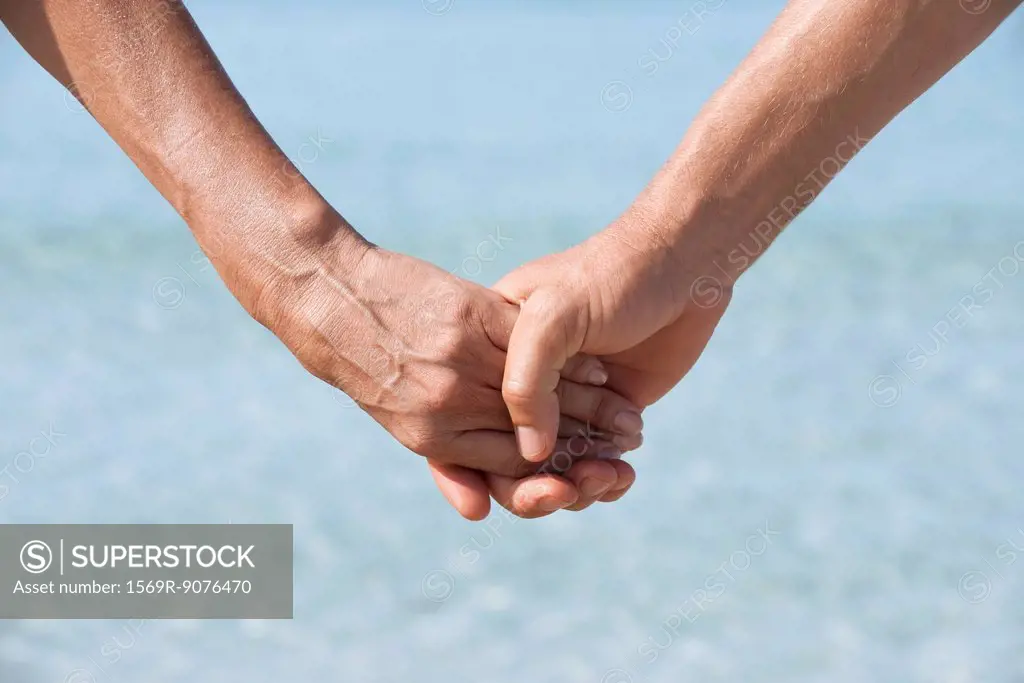 Couple holding hands, cropped