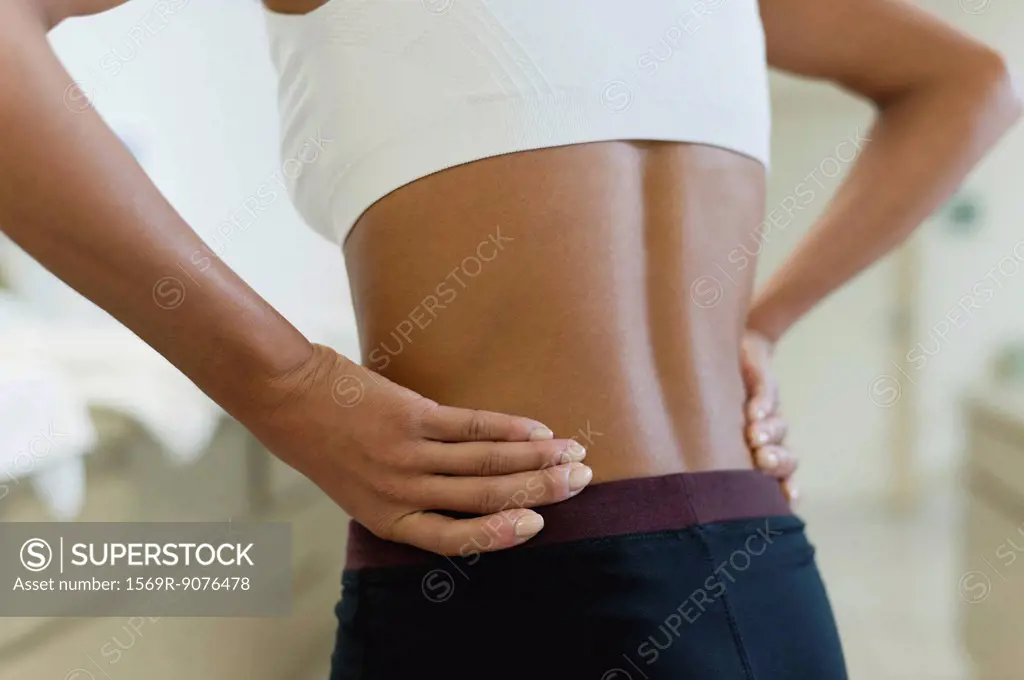 Woman with hands on lower back, mid section