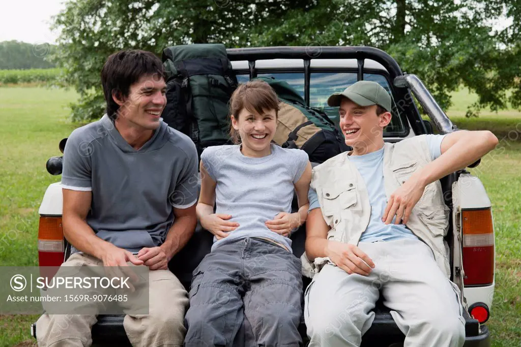 Friends sitting in back of pick_up truck, laughing