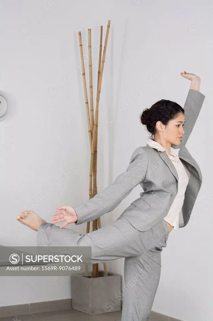 Young businesswoman doing yoga in office