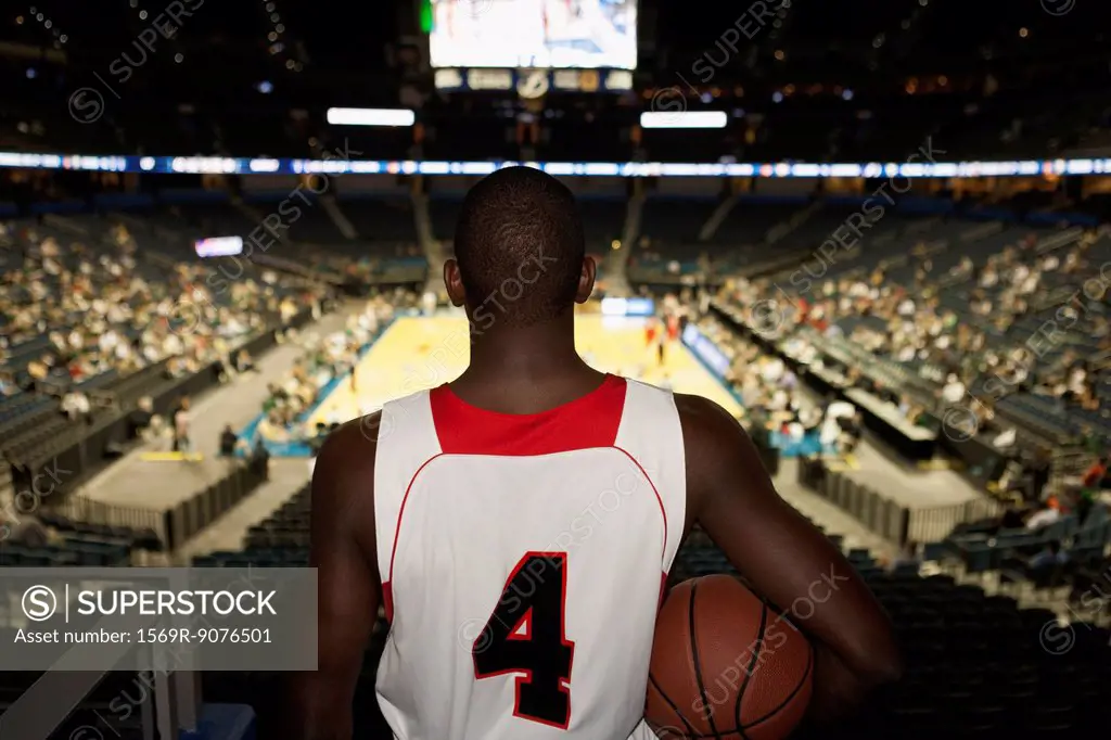 Basketball player looking down at stadium, rear view