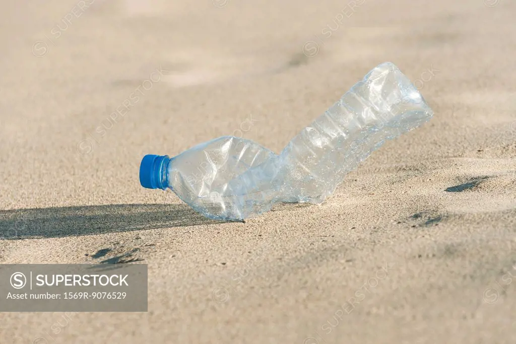 Empty plastic bottle on beach, close_up