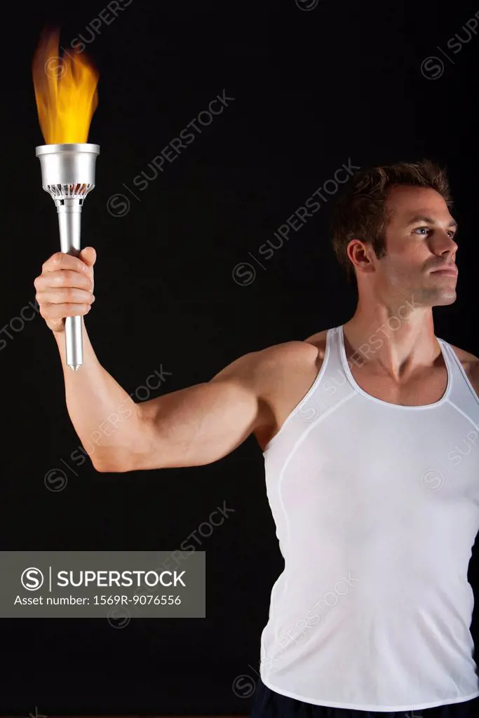 Male athlete holding up torch