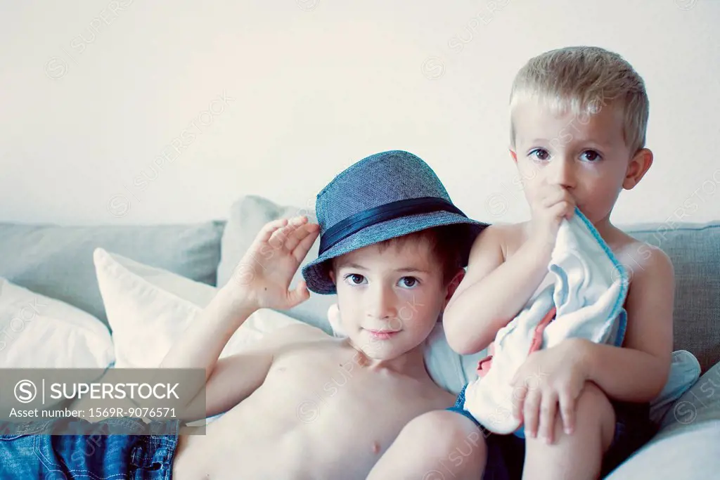 Young brothers together on sofa, portrait