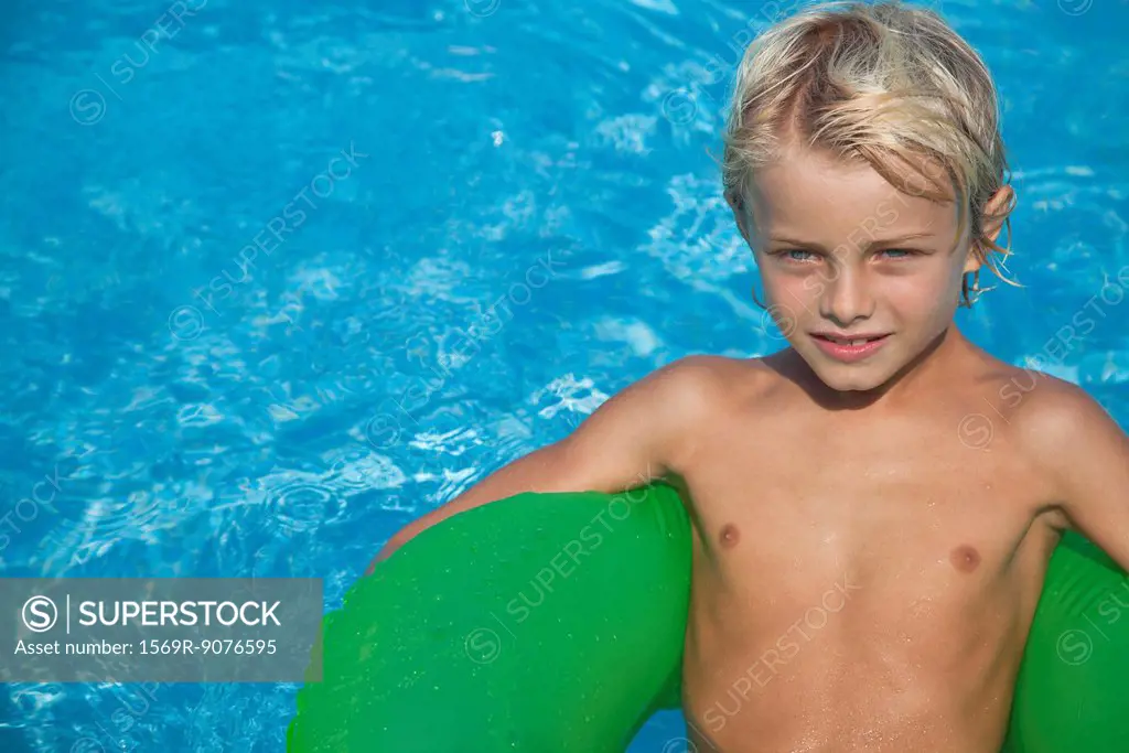 Boy relaxing on float in pool