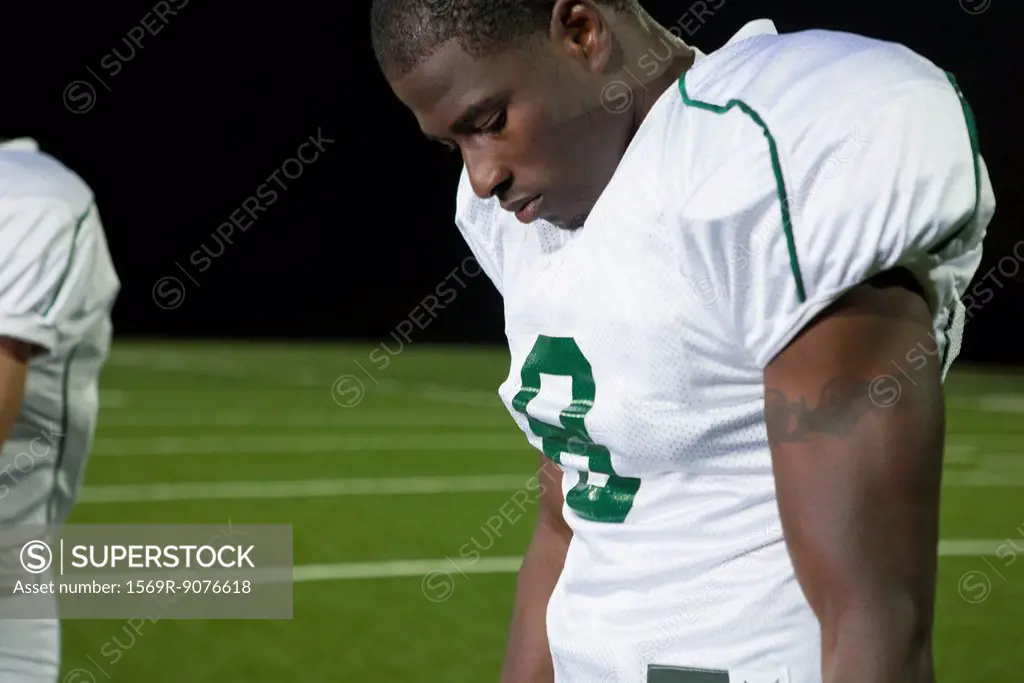 Football player looking down in disappointment