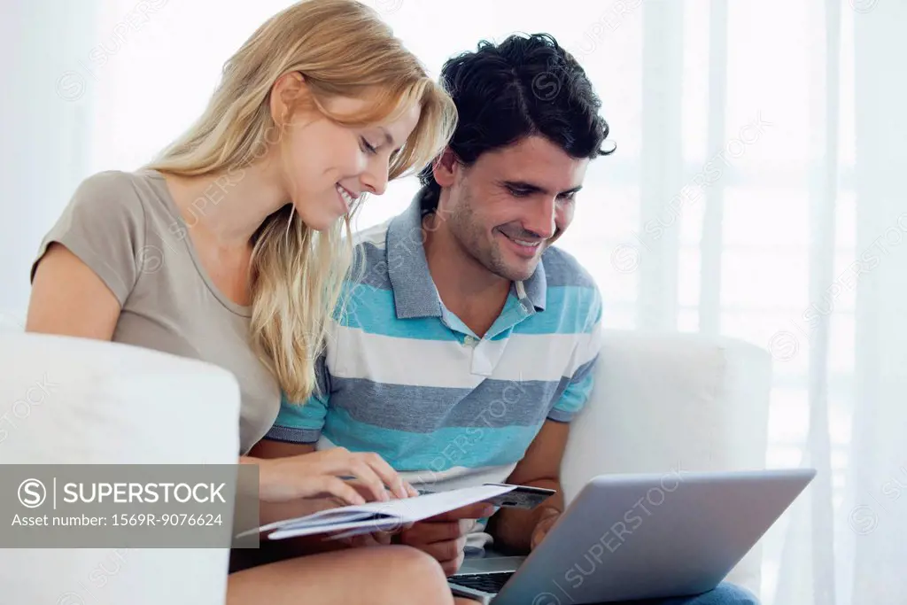 Couple shopping online with laptop computer